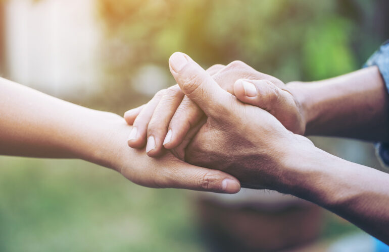 Caring hands reaching out and holding each other.